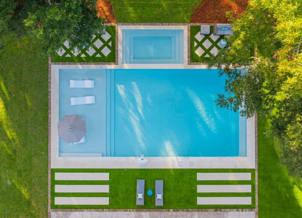 Aerial view of custom gunite pool and spa with turf and paver landscaping by Sunco Pools & Spas